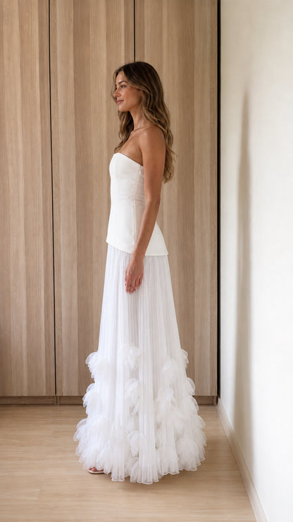 Side profile of woman in white strapless maxi dress