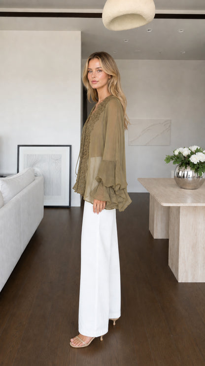 Model wearing olive blouse side profile view