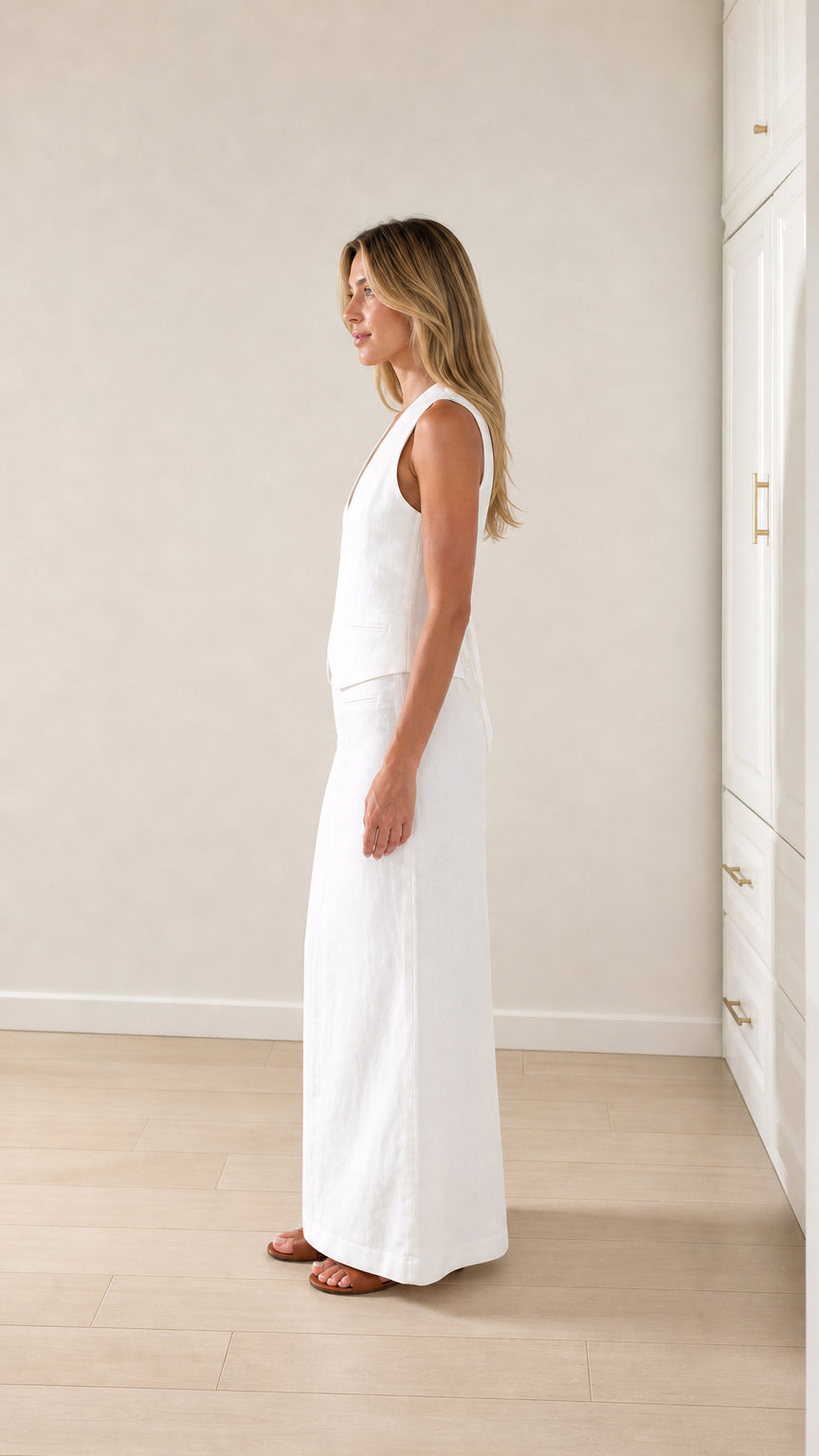 Side profile of woman wearing white vest and maxi skirt coordinates