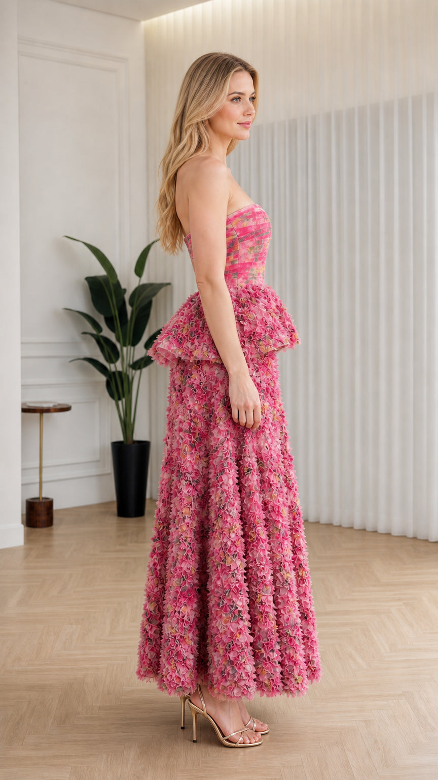 Side profile of model in pink strapless ruffle maxi dress