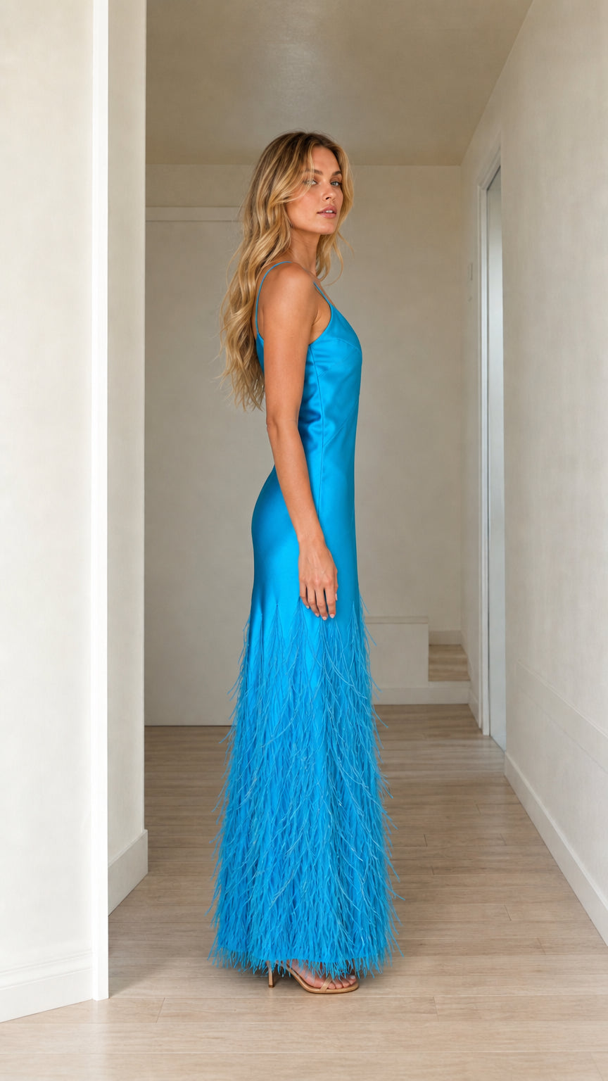 Side profile of woman in blue satin feather hem dress