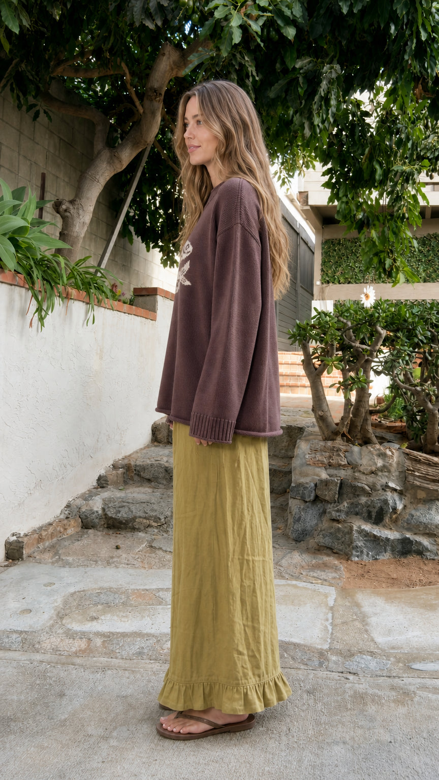 Side profile of model in Brown graphic fish knit pullover