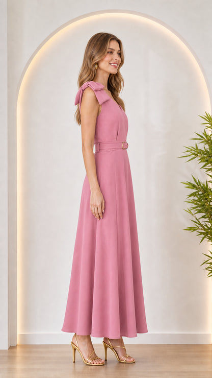 Side profile of woman in pink bow shoulder maxi dress