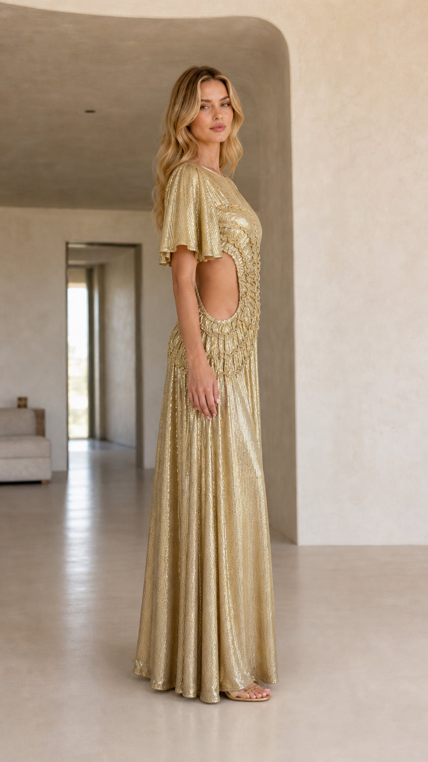 Side profile view of woman in a gold metallic maxi dress