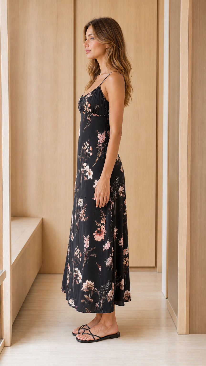 Side profile view of woman wearing black floral midi dress