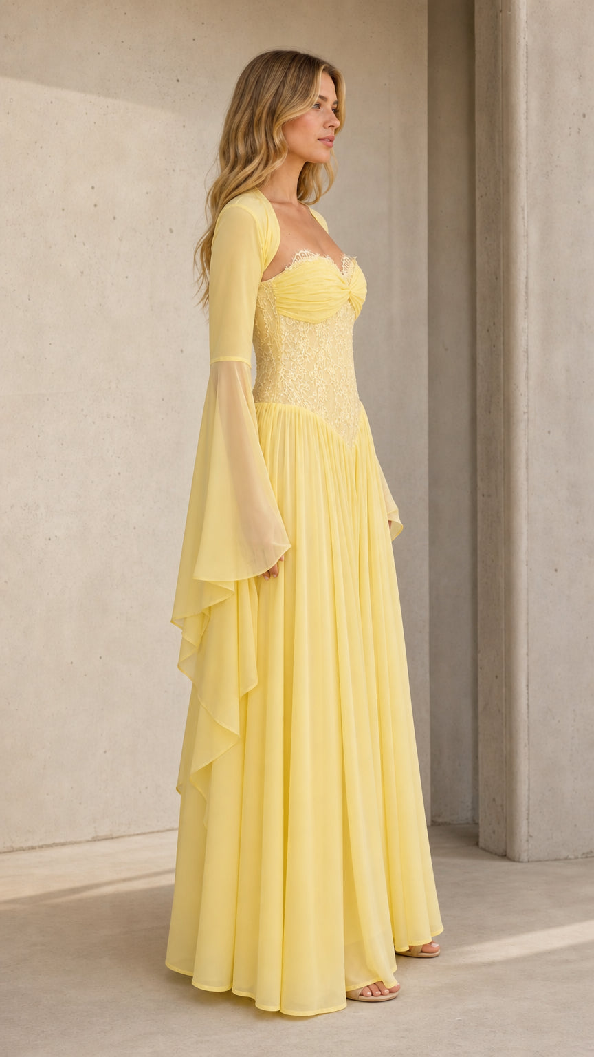 Three-quarter angle of model in pale yellow sweetheart evening gown with flared sleeves