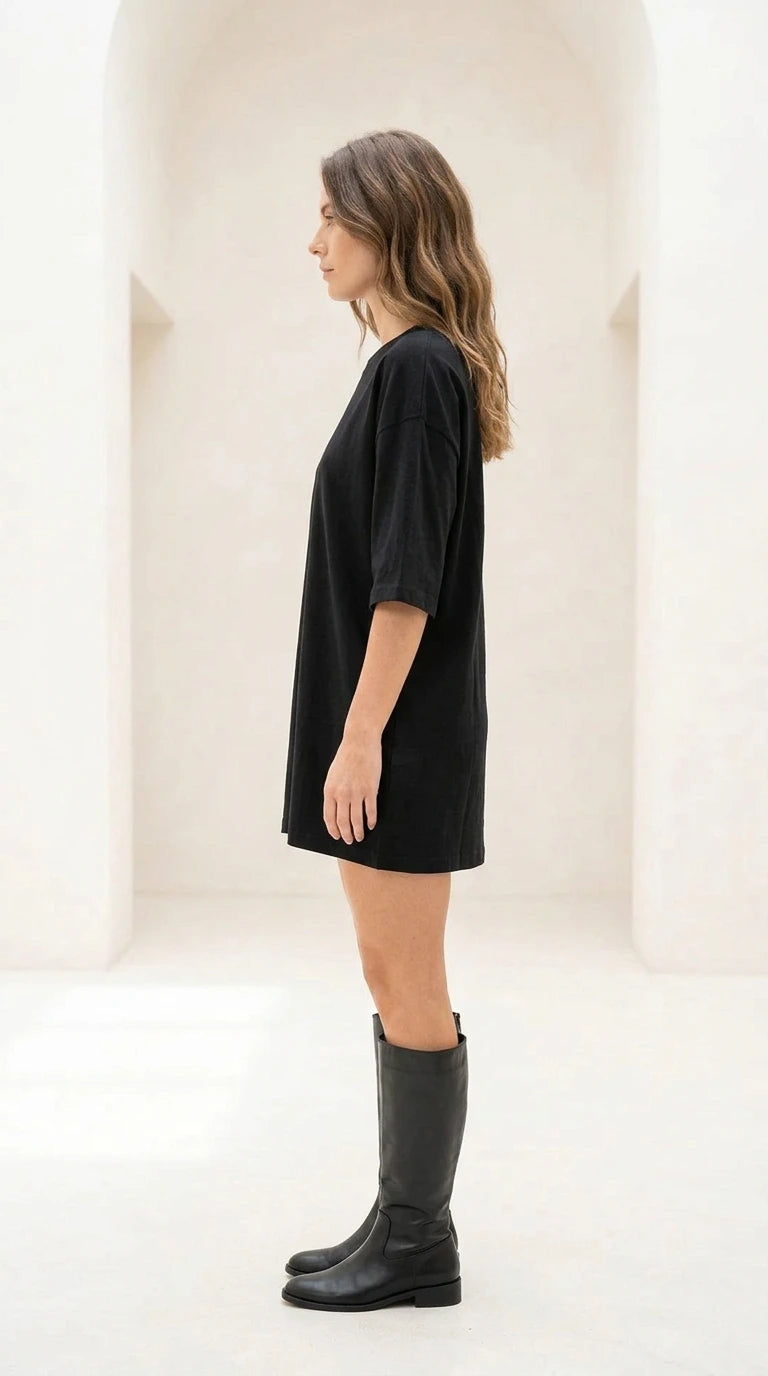 Side profile view of black oversized t-shirt dress