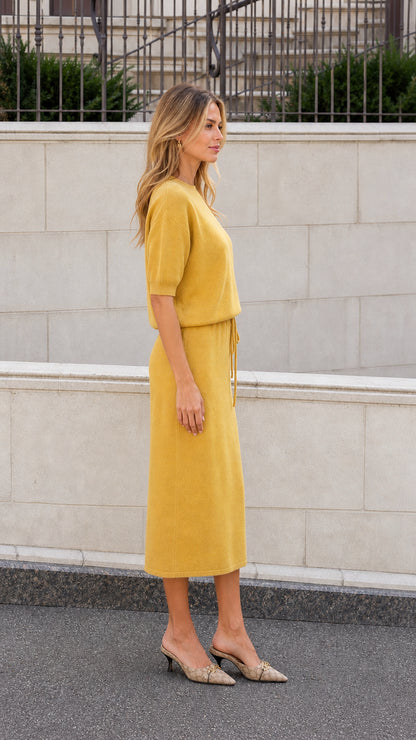 Mustard knit midi dress shown from the side with short sleeves and adjustable waist