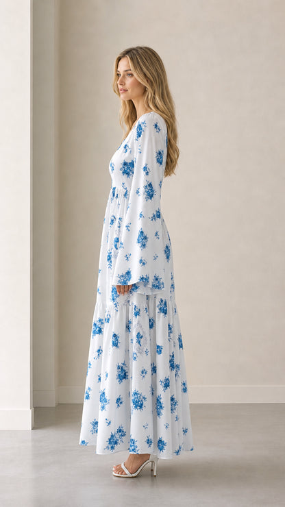 Side profile view of white floral long bell sleeve tiered maxi dress