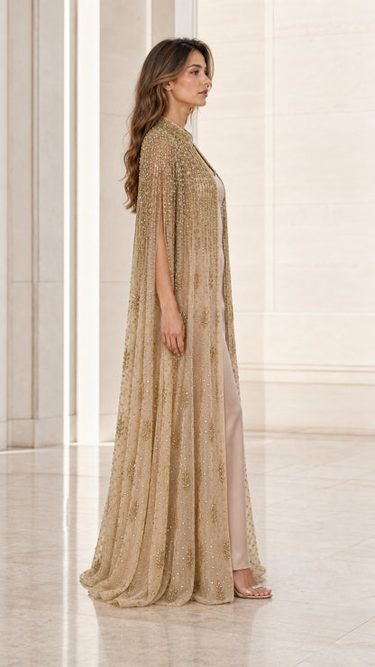 Side angle view of champagne gold embellished cape dress