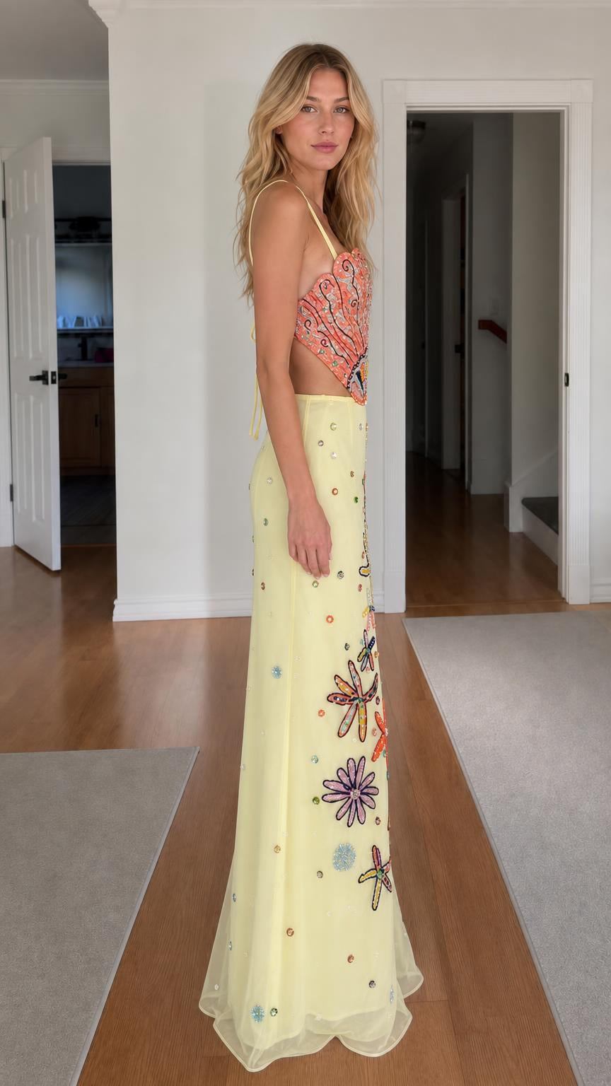 Side profile of model wearing yellow beaded two-piece dress