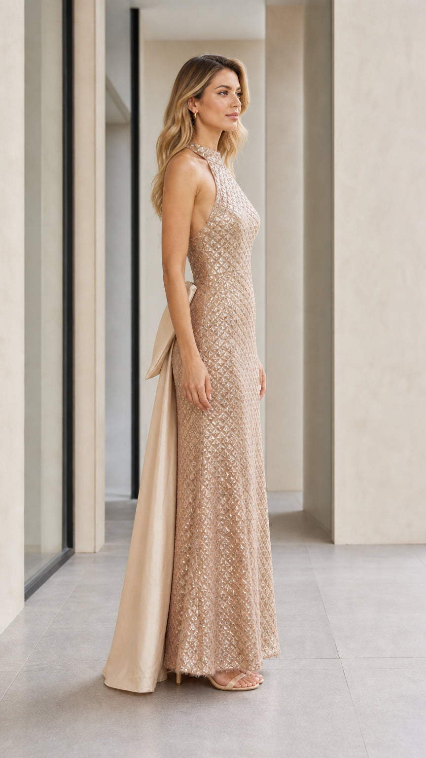Side profile view of champagne sequin gown with back train