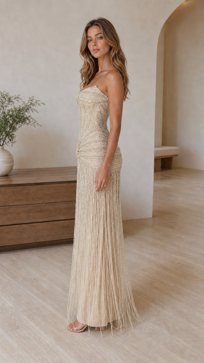 Angled side view of champagne beaded corset formal dress