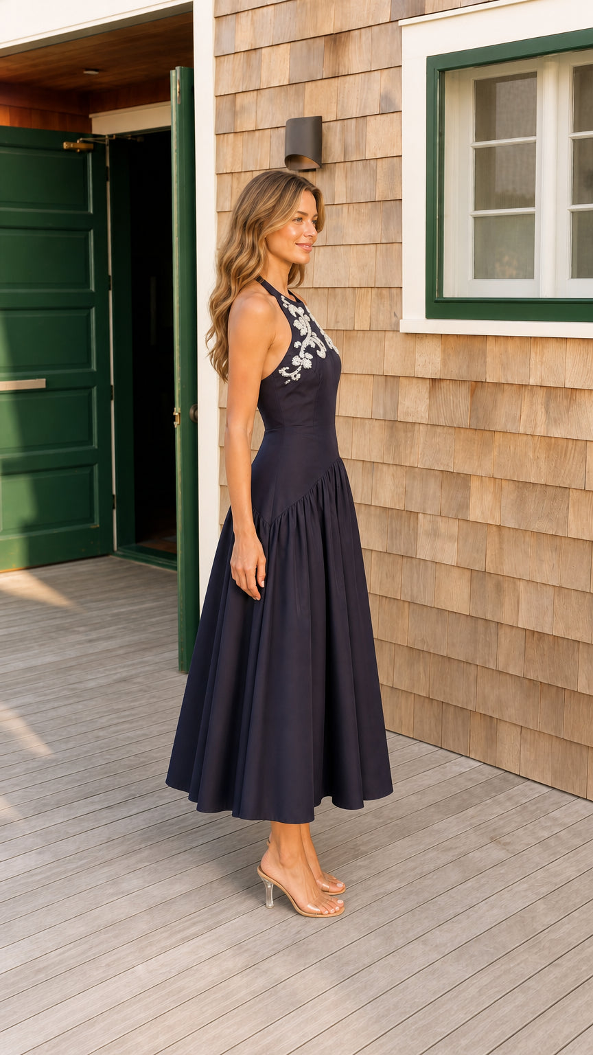 Side profile of navy blue halter open back evening midi dress