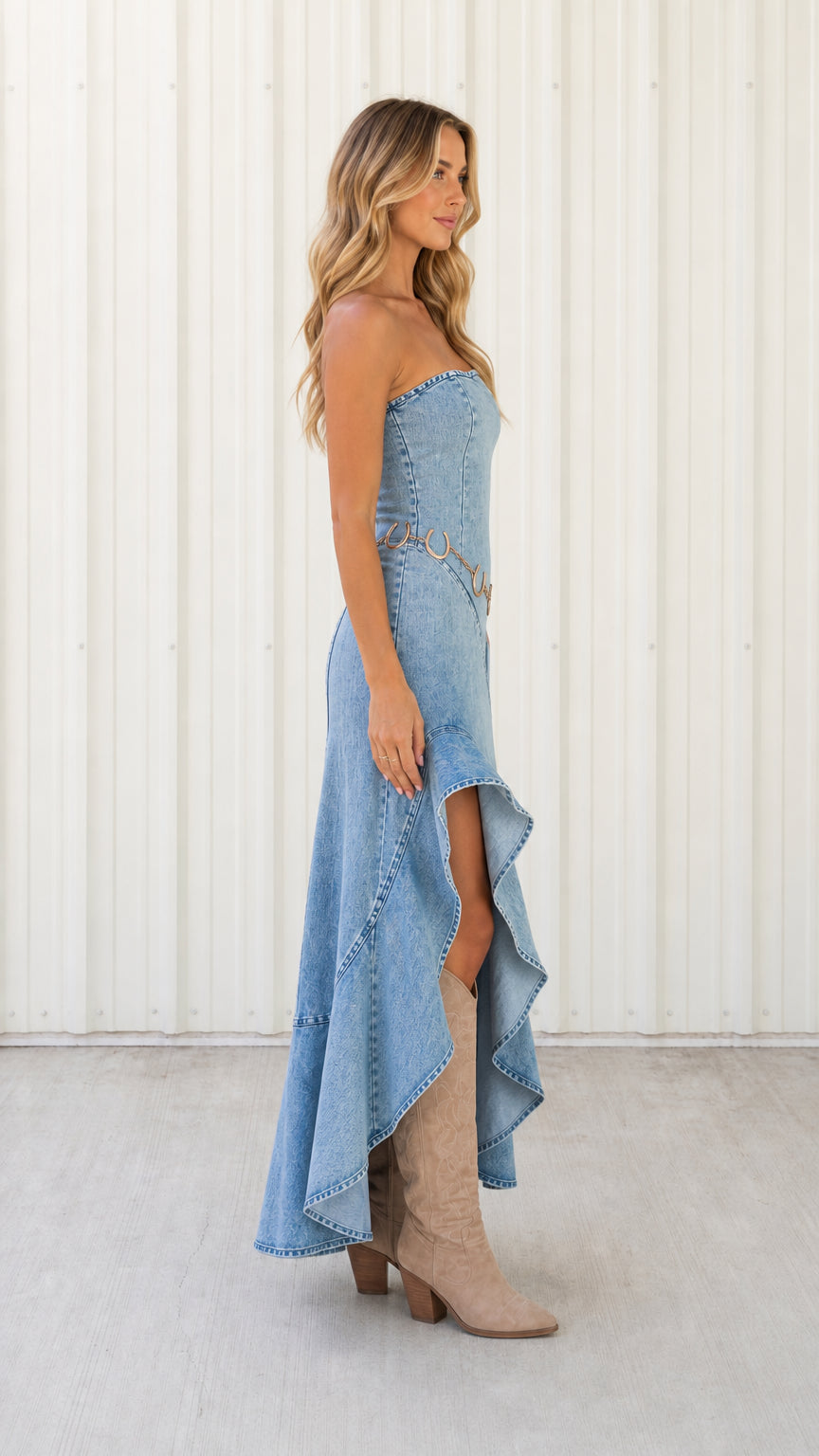 Side profile view of light blue strapless denim ruffle dress