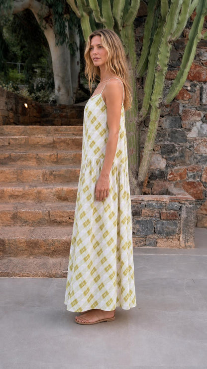 Side profile view of woman in sage green plaid maxi dress