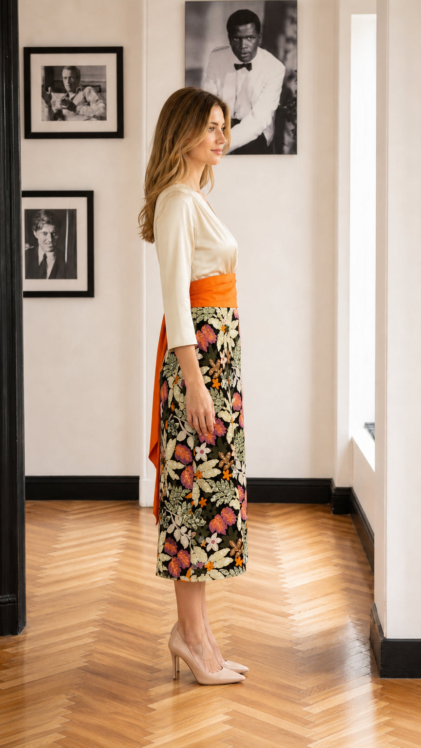 Side profile view of model in floral midi dress with orange sash belt