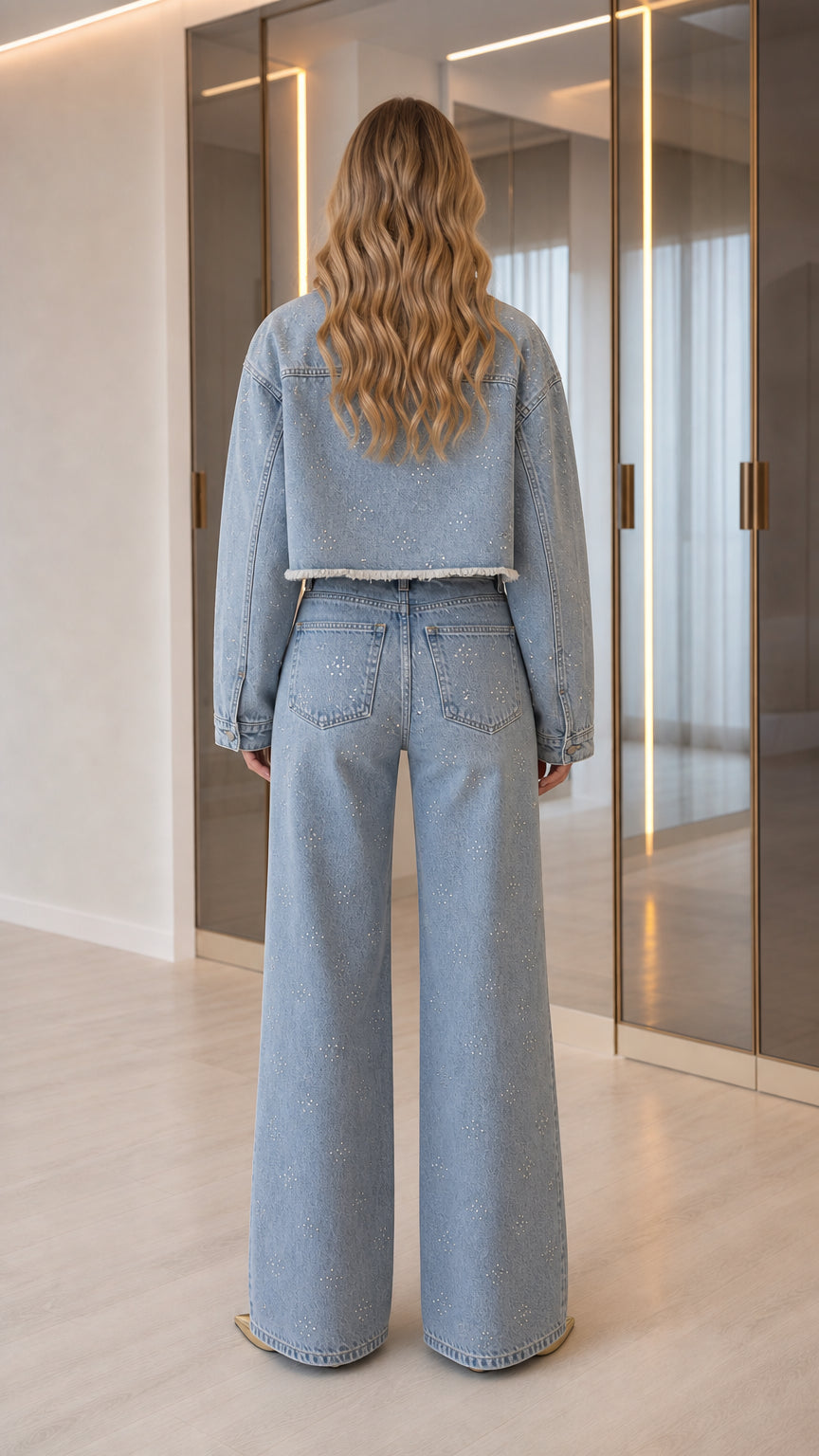 Back view of model wearing Light Blue cropped denim jacket and wide-leg pants with rhinestone details