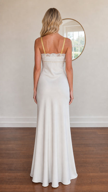 Model wearing white satin evening dress back view showing shoulder straps