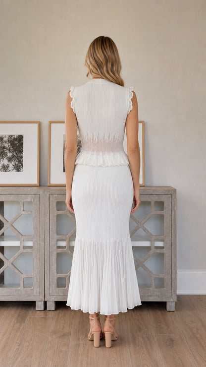 Back view of woman wearing white pleated midi dress