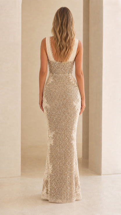 Rear view of model wearing champagne fitted beaded maxi evening dress