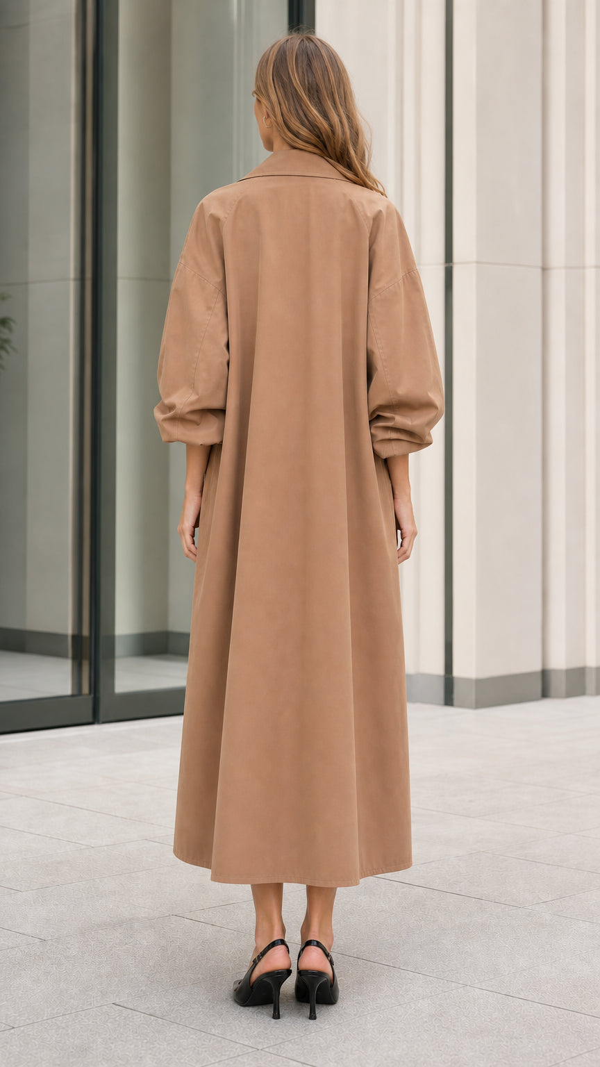 Back view of model showcasing the long sweeping silhouette of the camel trench coat