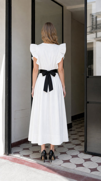 Back view of woman in white midi dress showing bow detail