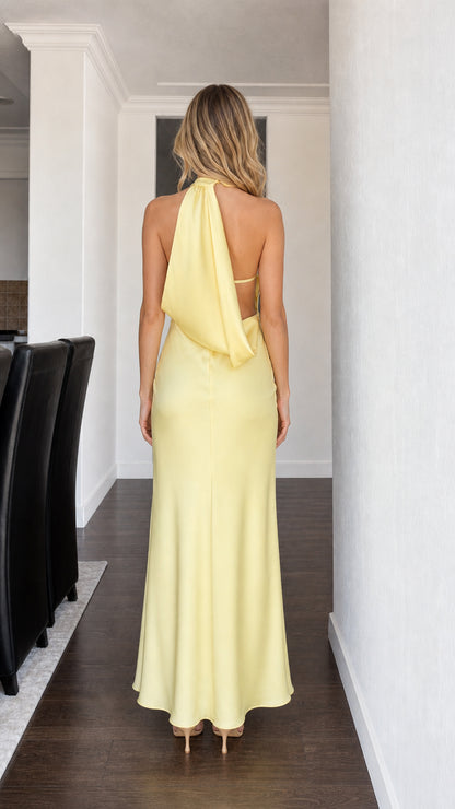 Back view showcasing draped open-back design of yellow dress