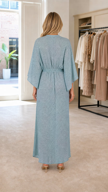 Back view of woman wearing light blue flowing maxi dress