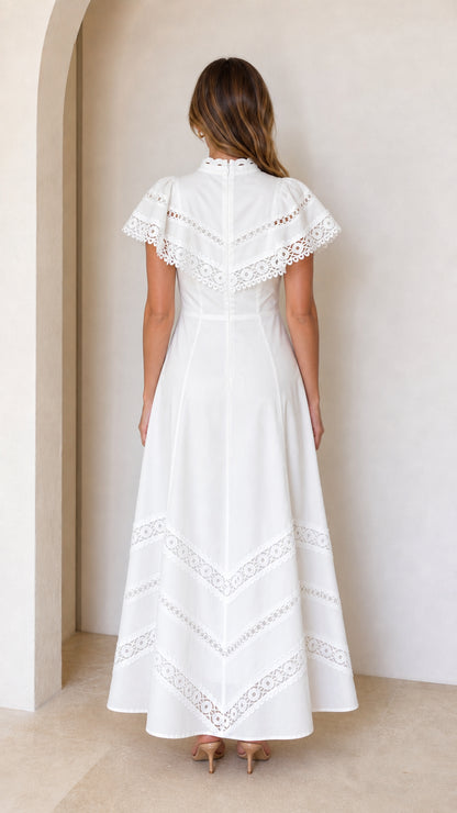 Back view of white lace maxi dress showing flutter sleeves and skirt hem