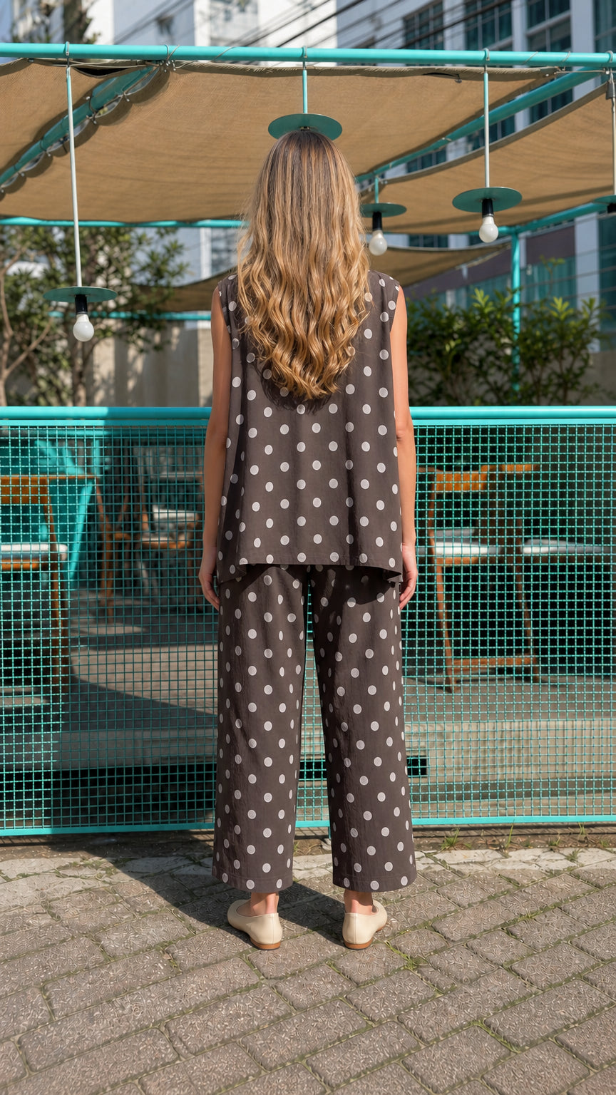 Model showing back view of brown polka dot vest and trousers set