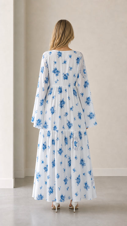 Back view of woman in white and blue floral tiered maxi dress