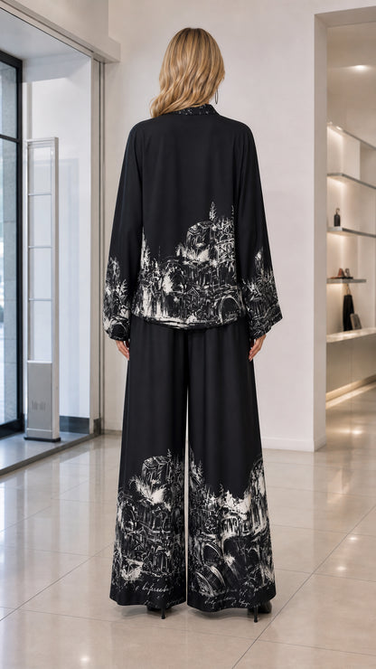 Back view of model wearing black printed long sleeve shirt and wide-leg pants