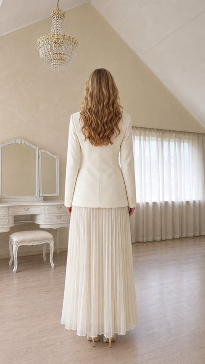 Back view of a woman wearing a white blazer and pleated skirt
