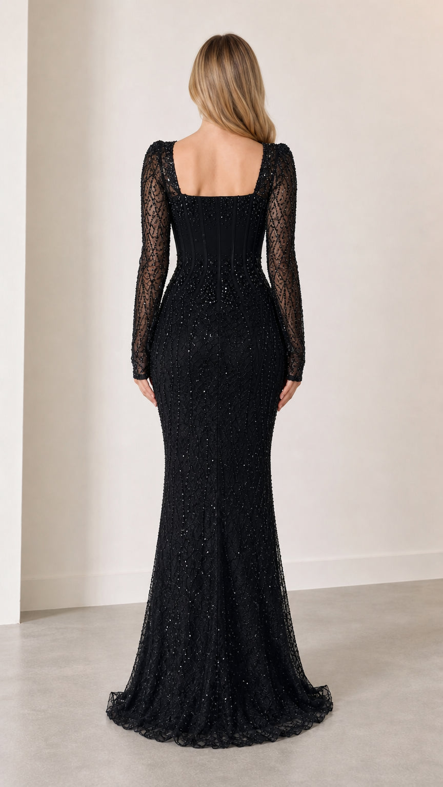 Back view of model in black long sleeve beaded evening dress with square back