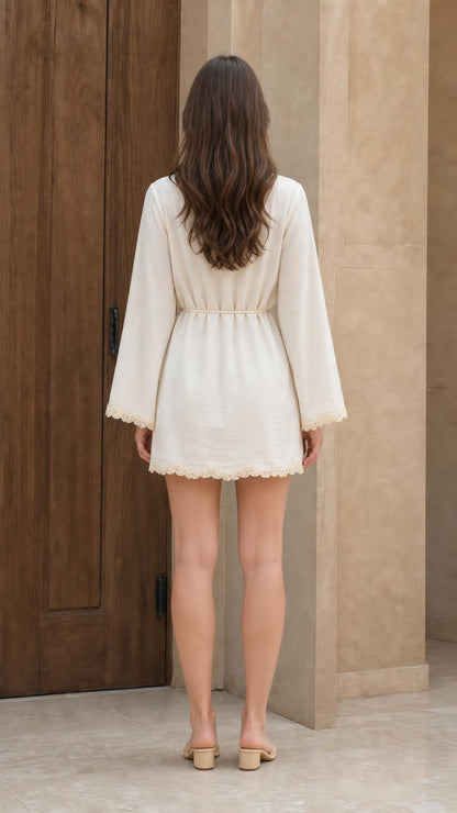 Back view of woman wearing white mini dress with bell sleeves
