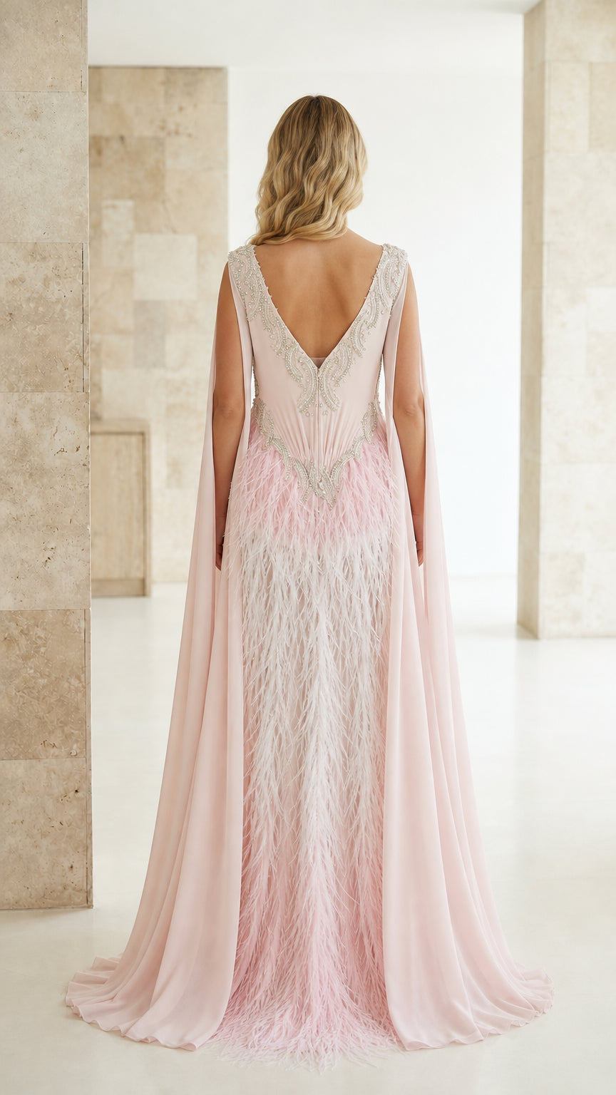 Back view of blush pink formal gown with flowing floor-length cape