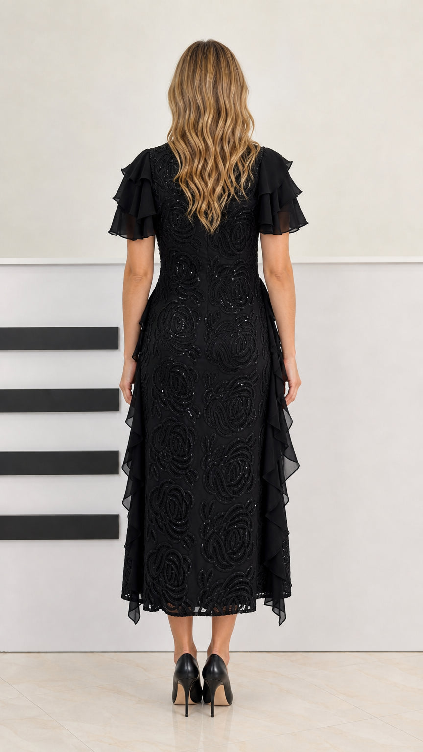 Back view of model in black beaded midi dress