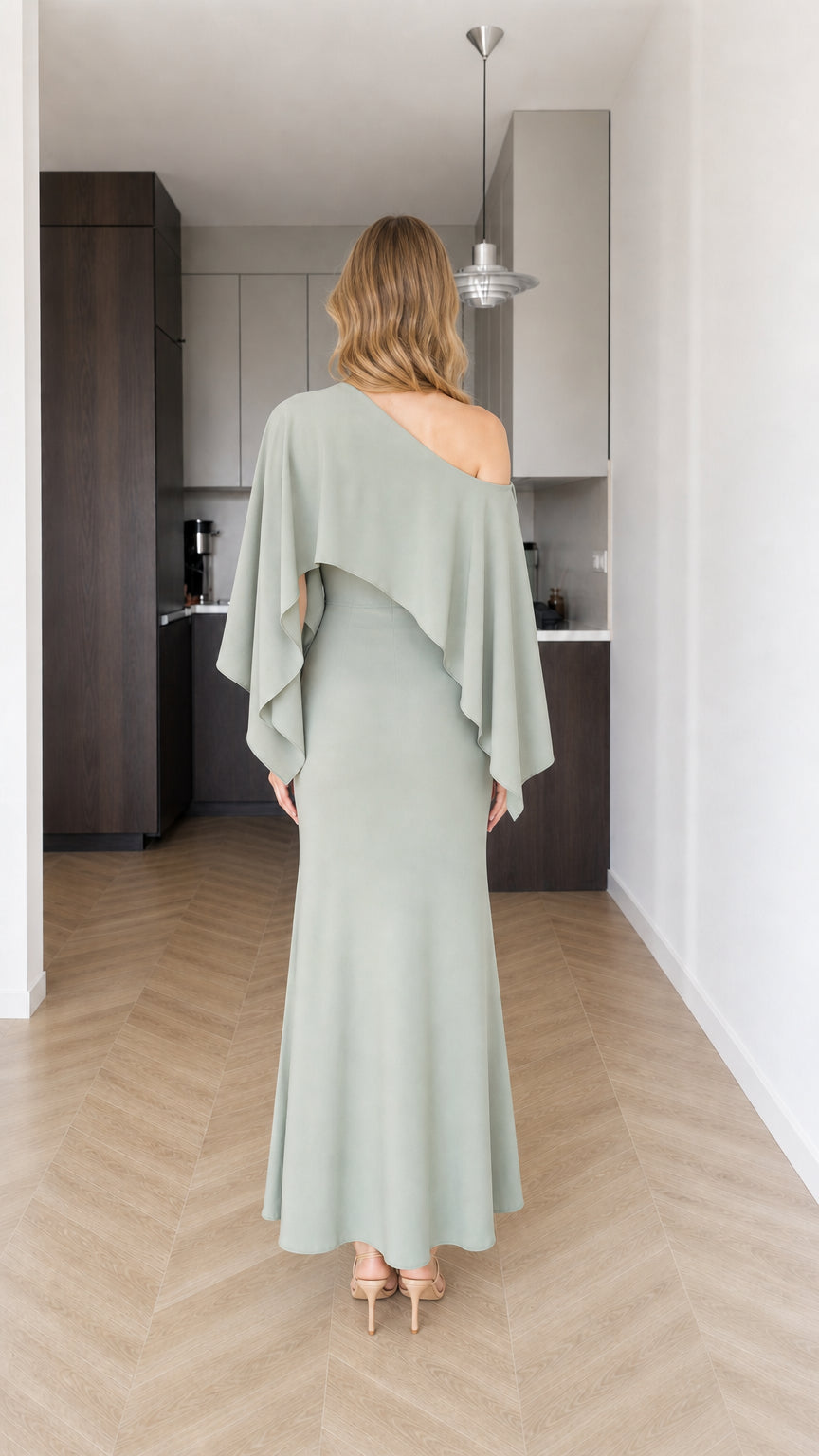 Back view of model showcasing cape detail on sage green maxi dress