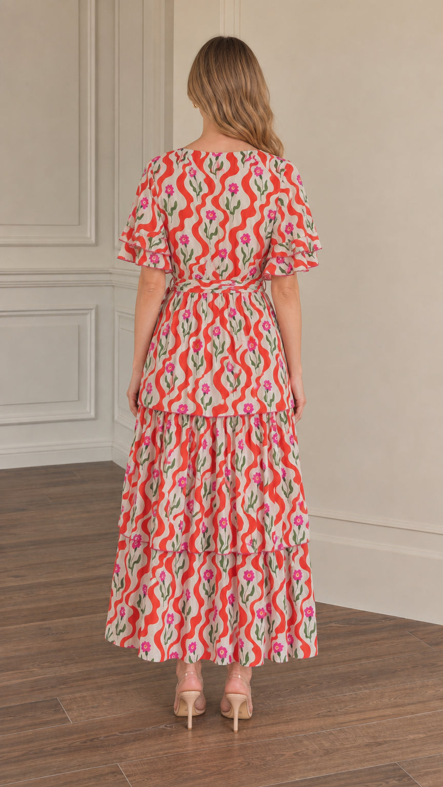 Back full-length view of woman wearing red floral wave print tiered maxi dress