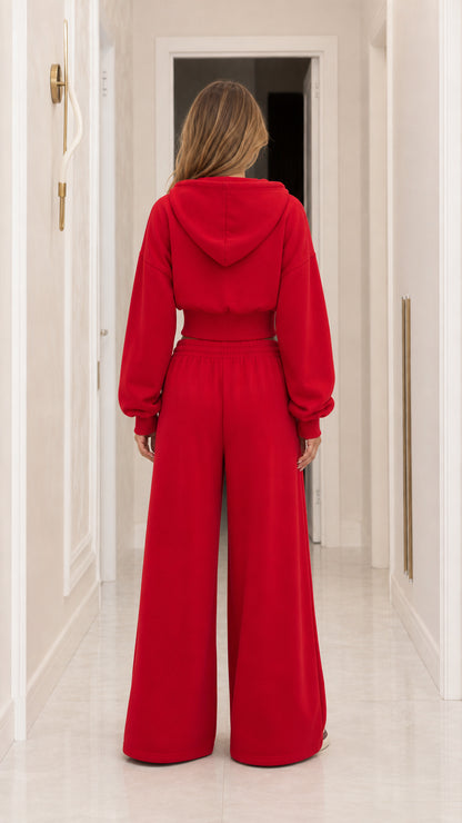 Back view of woman wearing red hooded cropped sweatshirt and wide-leg sweatpants