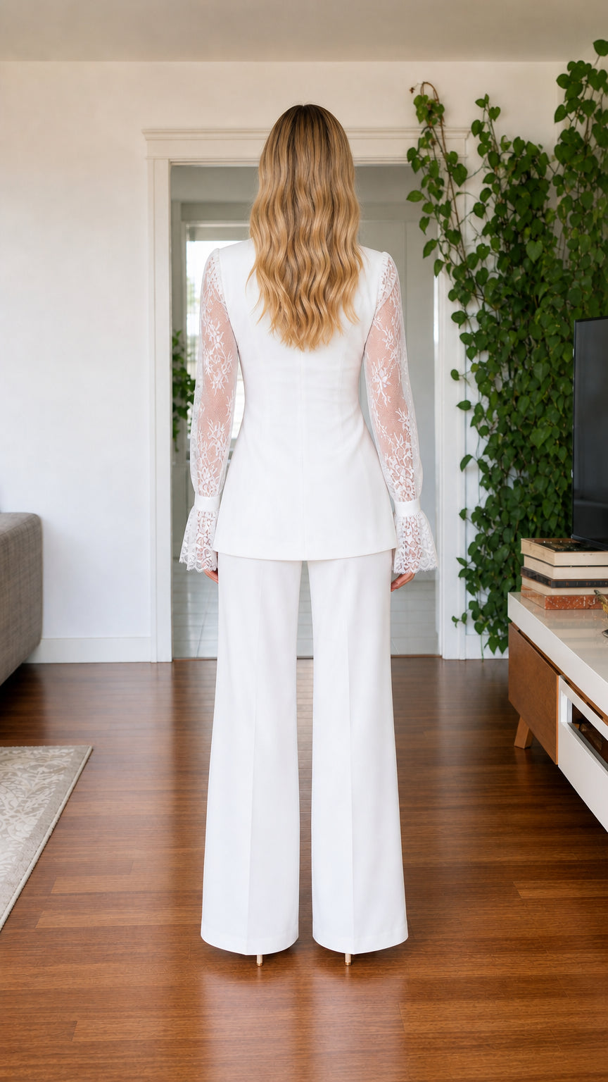 Back view of model wearing white pantsuit set with flared lace cuffs