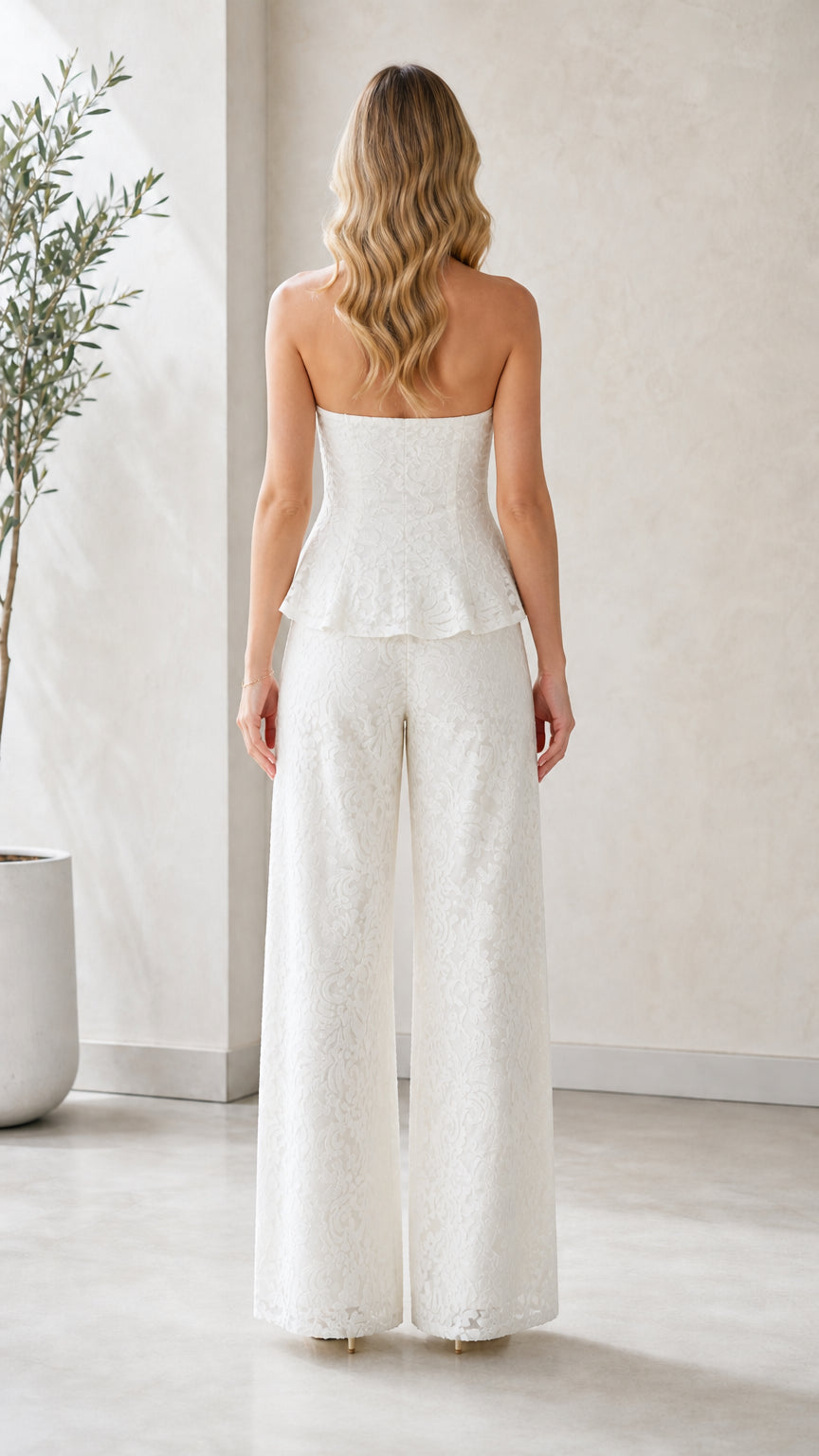 Model wearing white strapless lace peplum jumpsuit back view