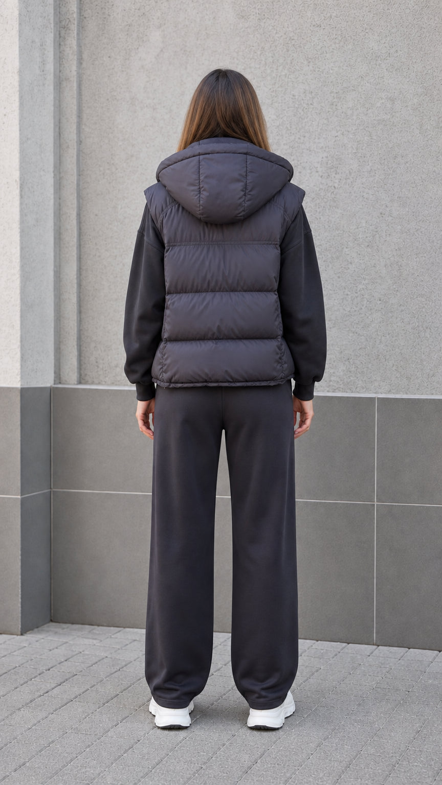 Back view of woman wearing black padded hooded vest