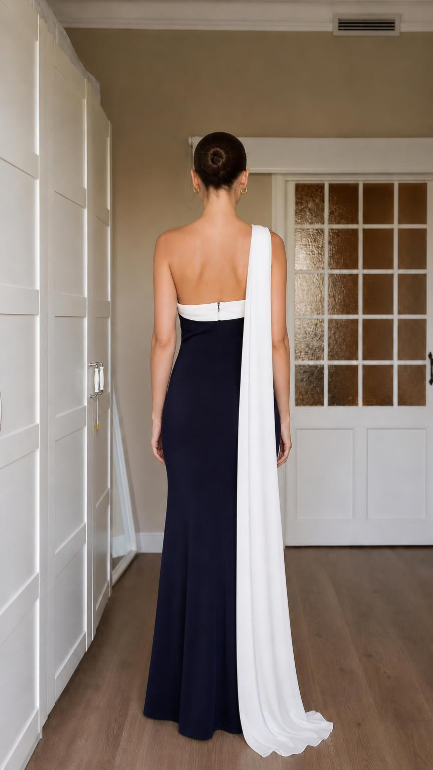 Back view of navy gown highlighting open upper back and cascading sash