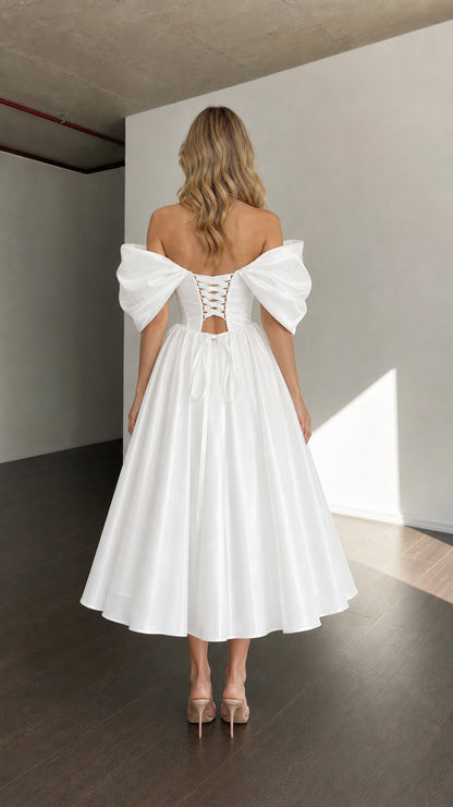 Back view of woman wearing white dress showing lace-up corset detail