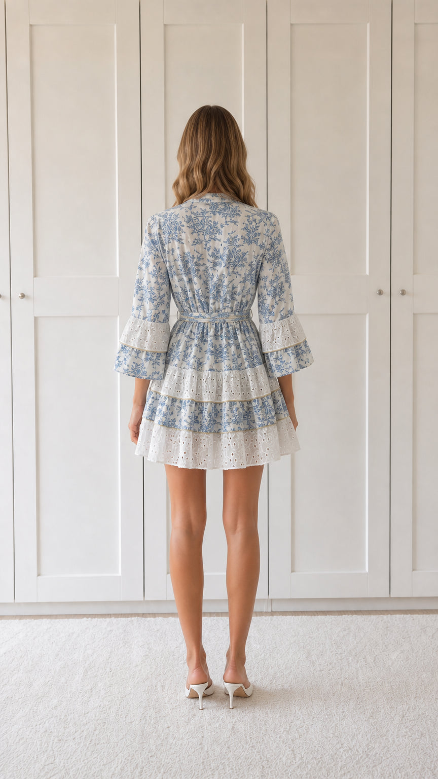 Back view of woman wearing blue floral print ruffle mini dress