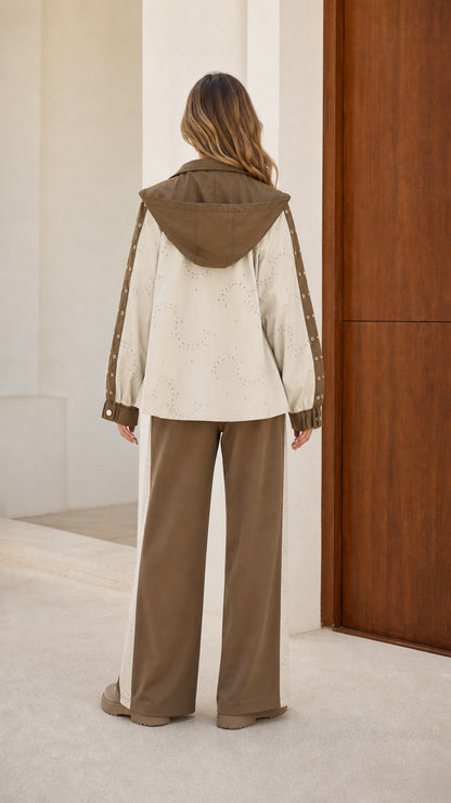 Back view of model showing the hood and eyelet panel details of the jacket