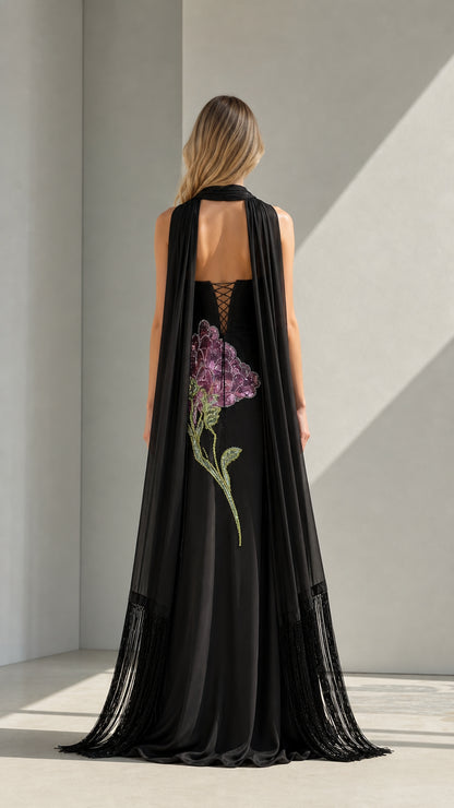 Back view of black evening gown showing cape and lace-up detail