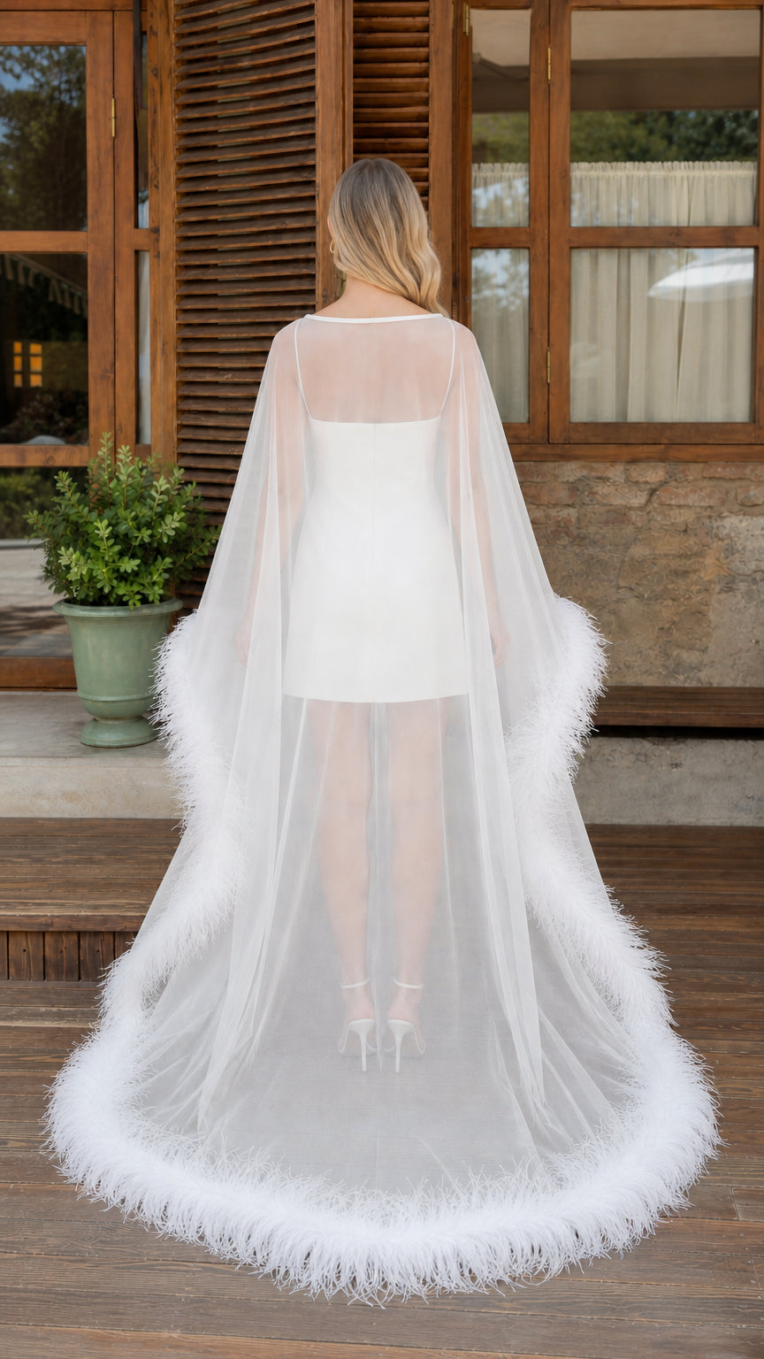 Back view of white sheer cape dress with long trailing hem